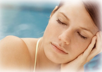 Woman with closed eyes and a calm expression holding her head in her hand